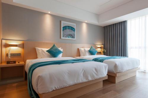 a hotel room with two beds and a window at Shanghai Baixia Pagoda Hotel in Shanghai