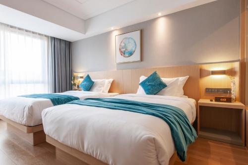 a hotel room with two beds and a window at Shanghai Baixia Pagoda Hotel in Shanghai