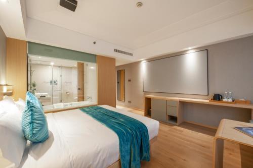 a hotel room with a large bed and a large screen at Shanghai Baixia Pagoda Hotel in Shanghai