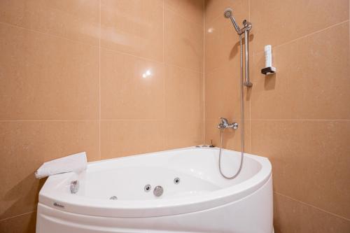 a bath tub in a bathroom with a shower at Villa Müllerbeck in Otepää