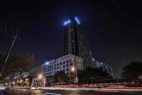a tall building with lights on top of it at night at Shanghai Baixia Pagoda Hotel in Shanghai