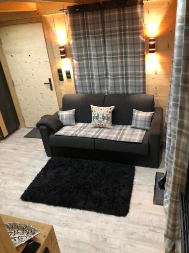 a living room with a couch and a rug at le mazot in Combloux