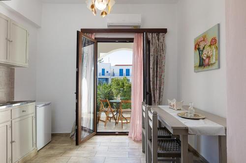 a kitchen with a table and a door leading to a patio at Kasteli Studios & Apartments in Panormos Rethymno