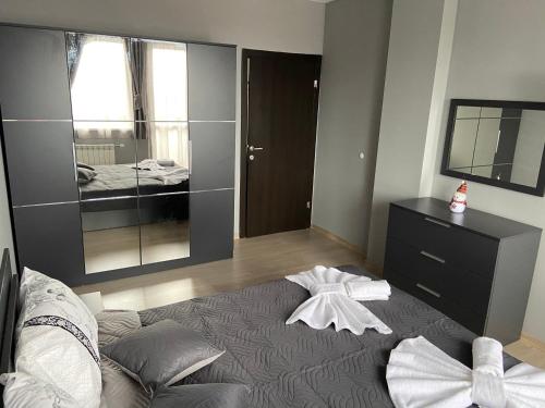 a bedroom with a large bed and a mirror at Ski Apartment Boyika Iglika 2 in Borovets