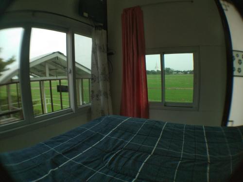 1 Schlafzimmer mit 2 Fenstern und 1 Bett mit einer blauen Decke in der Unterkunft Slowlife House Ayothaya in Phra Nakhon Si Ayutthaya