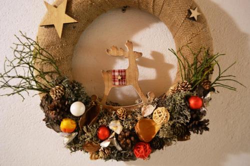 a christmas wreath with a reindeer on a wall at Chalupa pod Klepáčem in Králíky