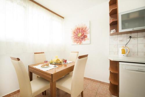 a dining room with a table and chairs in a kitchen at Apartment Hanna in Split