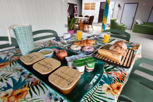 a table with bread and other food on it at La Maison des Oeillets Aéroport Roland Garros in Sainte-Marie
