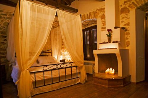 a bedroom with a canopy bed with a fireplace at Villa Amanti in Áno Gatzéa