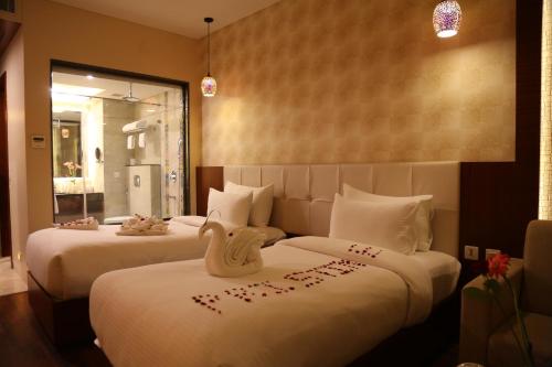 two beds in a hotel room with hearts on them at Pristine Hotel, Varanasi in Varanasi