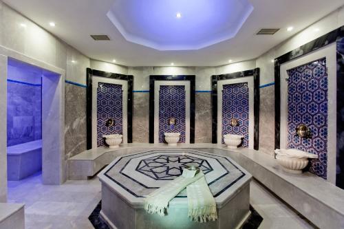 La salle de bains est pourvue d'une baignoire et d'une douche avec du carrelage bleu. dans l'établissement Quadas Hotel - Adult Only, à Marmaris