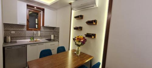 eine Küche mit einem Holztisch mit einer Blumenvase darauf in der Unterkunft JOANDI Apartments in Gevgelija