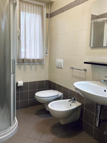a bathroom with a toilet and a sink at Rimini Bay Suites&Residence in Rimini