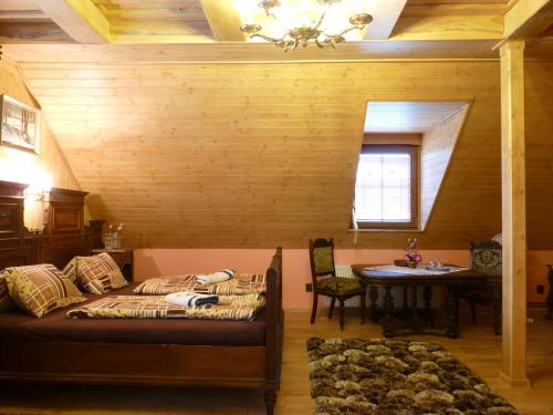a bedroom with a bed and a table and a window at Penzion Obora in Prostřední Bečva