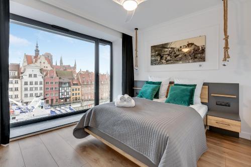 a bedroom with a bed and a large window at Deo Plaza by Blue Mandarin in Gdańsk