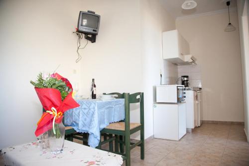 a kitchen with a table and a tv on the wall at Meandros in Almirida