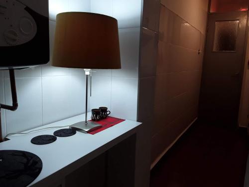 un tavolo con una lampada e un libro sopra di Cocooning in a Lovely Mountain suite - One ad Azuga