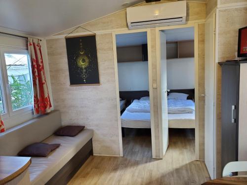 a small room with two beds and a window at Mobil home récent clim 3ch Camping3* piscine in Argelès-sur-Mer