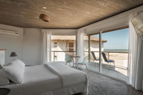 um quarto com uma cama e vista para o oceano em MarAdentro Apart Hotel & Suites em Punta Del Diablo