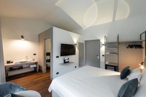 a bedroom with a large white bed and a sink at Castel Hörtenberg in Bolzano