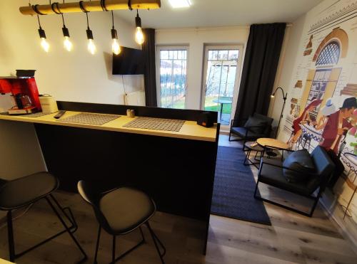 a bar in a room with chairs and a counter at City Apartment in Chemnitz