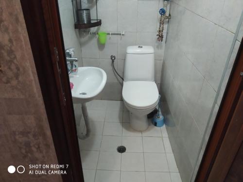 a small bathroom with a toilet and a sink at Апартмент Паисий 15 in Varna City