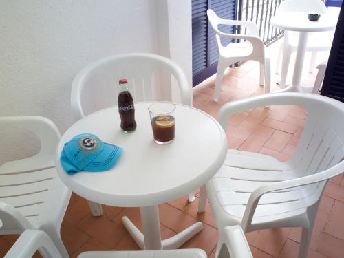 a white table with a bottle and a drink on it at Hotel Els Pins in Platja  d'Aro