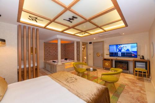 a bedroom with a bed and a tv and a living room at Wyndham Istanbul Old City in Istanbul