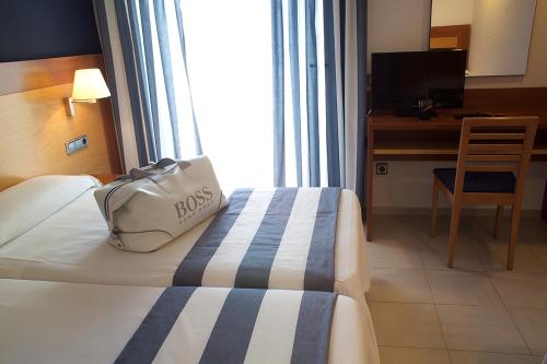 a hotel room with a bag sitting on a bed at Hotel Els Pins in Platja  d'Aro