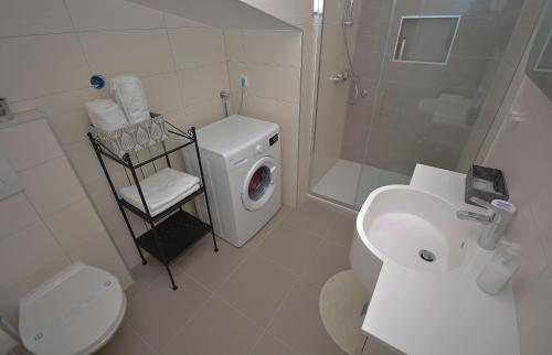 W łazience znajduje się umywalka i pralka. w obiekcie Apartment 3 with the private jacuzzi w mieście Turanj