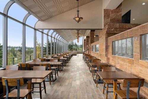 a row of tables and chairs in a room with windows at Baymont by Wyndham Bremerton WA in Bremerton
