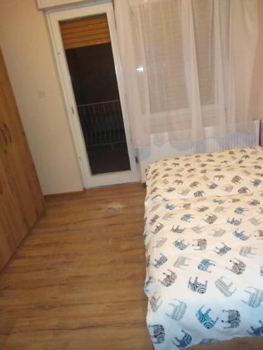 a bedroom with a bed and a wooden floor at Evelin sobe in Bačka Topola