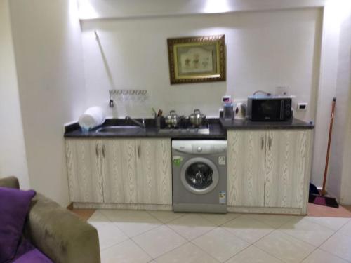 a kitchen with a sink and a washing machine at SARAYA AWAD HEGAZI STREET- families only in Alexandria