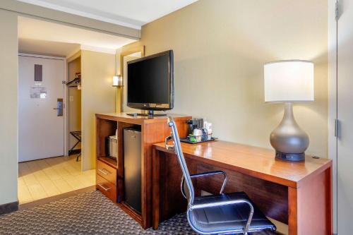 a living room with a desk, chair and a television at Comfort Inn Denver Central in Denver
