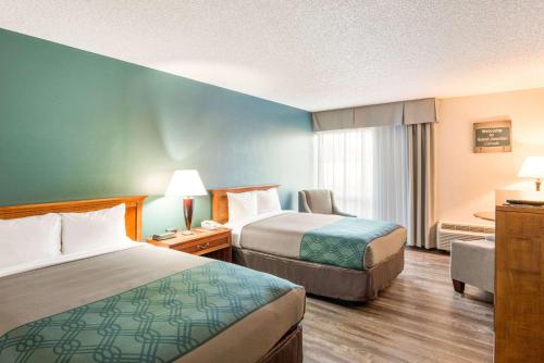 Habitación de hotel con 2 camas y escritorio en Econo Lodge, en Grand Junction