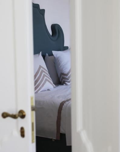 a bedroom with a bed with white sheets and pillows at Palazzo Maritati in Nardò