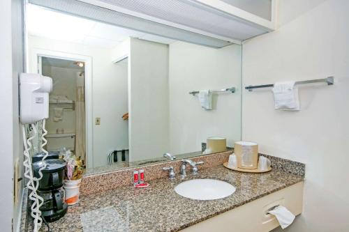 ein Bad mit einem Waschbecken und einem Spiegel in der Unterkunft Econo Lodge Inn And Suites - Pilot Mountain in Pilot Mountain