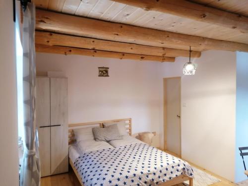 1 dormitorio con 1 cama en una habitación con techos de madera en Garac Zlatibor Vikendica en Zlatibor