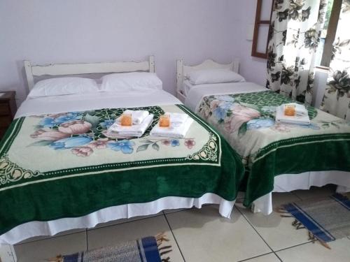 duas camas sentadas uma ao lado da outra num quarto em Pousada Efraim em Tiradentes
