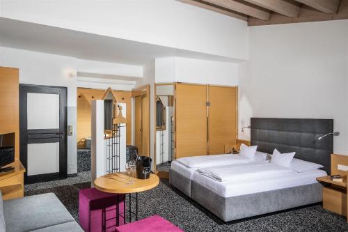 マトライ・イン・オストティロルにあるHotel Rauterのベッドルーム(大型ベッド1台、テーブル付)