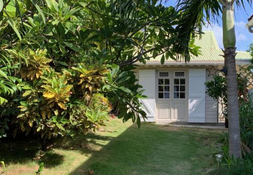 a white house with a palm tree in front of it at Le Paradis des Rebelles in Terre-de-Haut