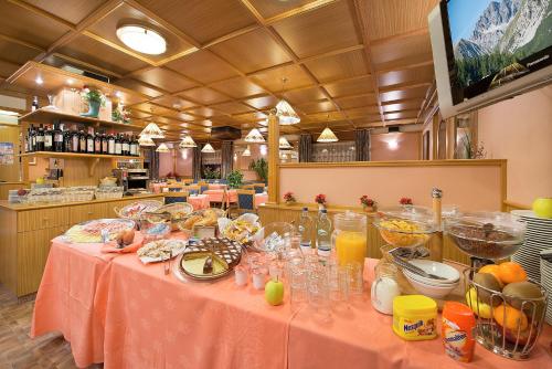 a table with a pink table cloth with food on it at Hotel Centro's in Livigno