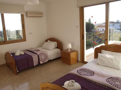 Un dormitorio con dos camas y un balcón. en Mariandy Villa 2, en Bahía de Coral
