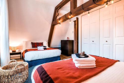 Habitación con 2 camas y una silla. en Le Plateau Ski Inout W 3bdrs W Pool Access en Mont-Tremblant