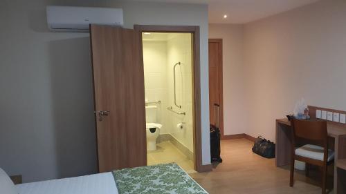 a bedroom with a bed and a bathroom with a toilet at Vista Azul Flat Service in Domingos Martins