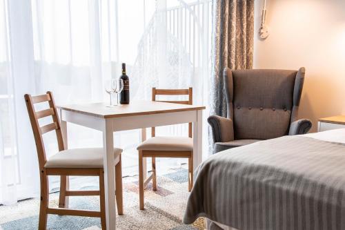 a room with a table and two chairs and a bed at Bungalows at Sierra Golf Resort in Wejherowo