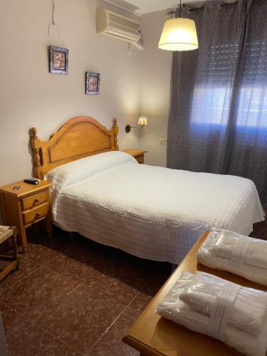 Habitación de hotel con 2 camas y mesa en Hostal Parapanda, en Granada