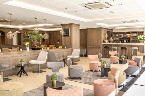 a lobby with chairs and tables and a bar at Les Jardins de St Cloud in Saint-Cloud