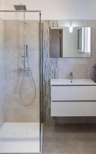 une salle de bain avec un lavabo et une douche dans l'établissement les terrasses d'arutoli, à Porto-Vecchio