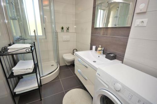 een witte badkamer met een wasmachine bij Apartment 2 with the swimming pool in Turanj